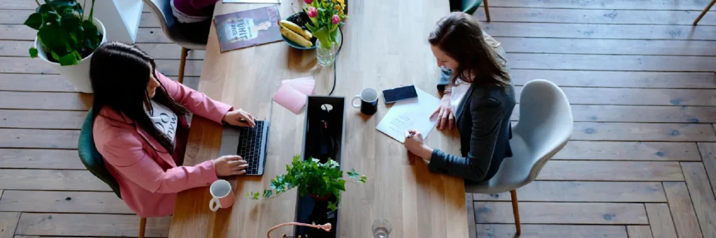Reunión en mesa vista cenital; asesoría laboral para empresas y trabajadores.