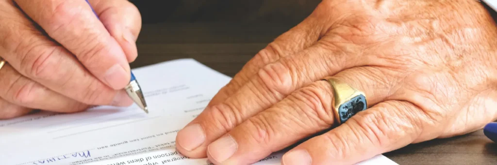 Mano firmando un documento; aviso legal y política de privacidad.