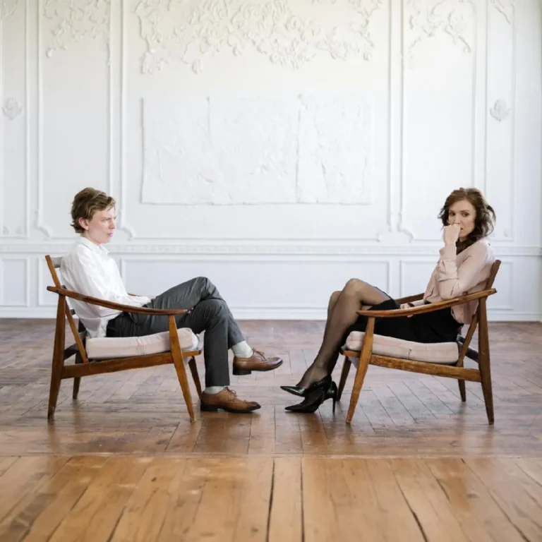 Pareja sentada dialogando en sala; asesoramiento en separaciones y divorcios.