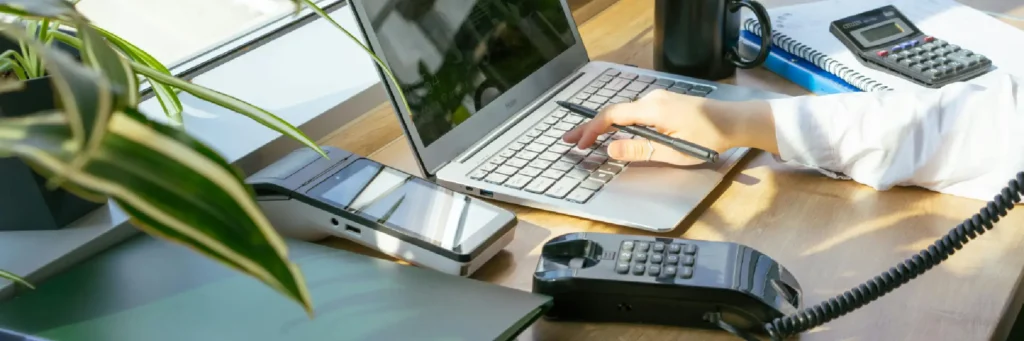 Portátil y calculadora en primer plano; accede a herramientas legales útiles y gratuitas.